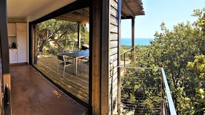 Ein Balkon mit Holzboden, einem Tisch und Stühlen.
