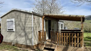A small wooden cabin with a deck and a covered porch.