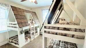 A room with two bunk beds, a ceiling fan, and a window with curtains. - Gorgeous Conway Home A/C, Hot Tub & Full Game Room (Conway)