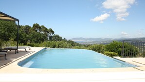 A swimming pool with a view of distant mountains and a clear sky. - La Cadière, Villa 230m2 in a quiet area, superb panoramic view, infinity pool (La Cadière-d'Azur)