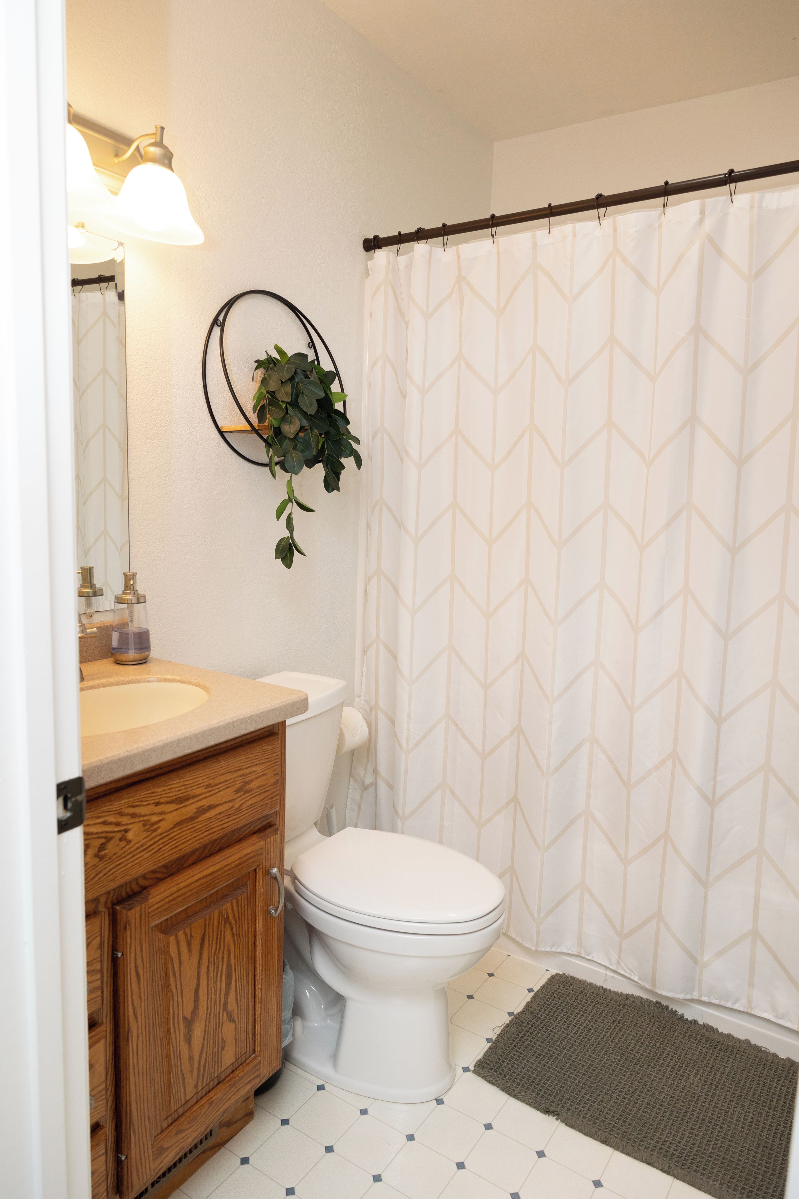 A bathroom with a toilet, sink, and mirror.