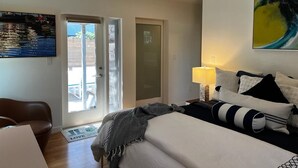 Hotellihuone, jossa on sänky, työpöytä, tuoli, ovi ja ikkuna.