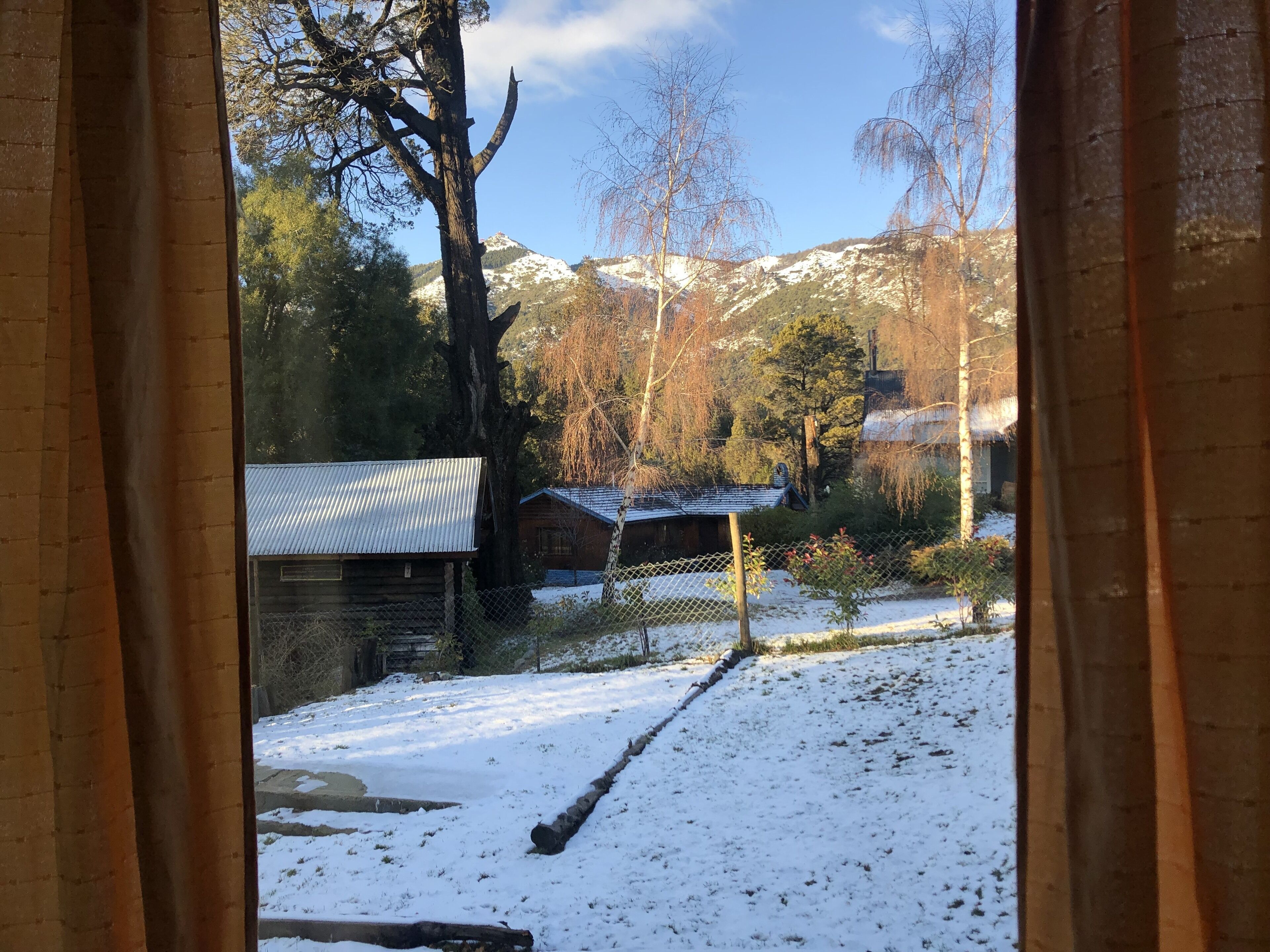 Un paysage enneigé avec une cabane et une montagne en arrière-plan.