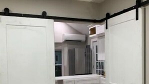 Une pièce avec une kitchenette, des placards blancs et un luminaire au plafond.