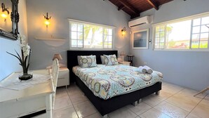 Een slaapkamer met een bed, nachtkastjes, een spiegel en een raam.