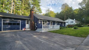 Une maison à deux étages avec un garage, un porche à l’avant et une pelouse bien entretenue.