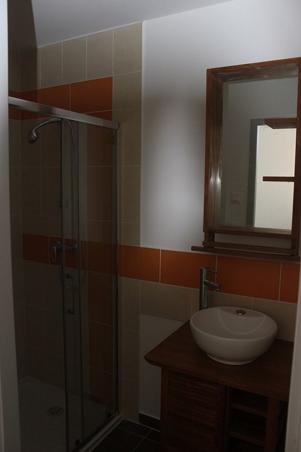 Un baño con cabina de ducha de vidrio, un lavabo y un espejo.