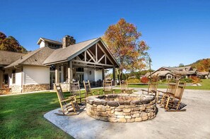 A house with a stone fire pit, outdoor seating, and a covered patio area.