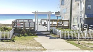 A gated entrance with a pergola, a white picket fence, and a view of the ocean. - Heated Pool • Steps to Beach w/ Private Access (Miramar Beach)