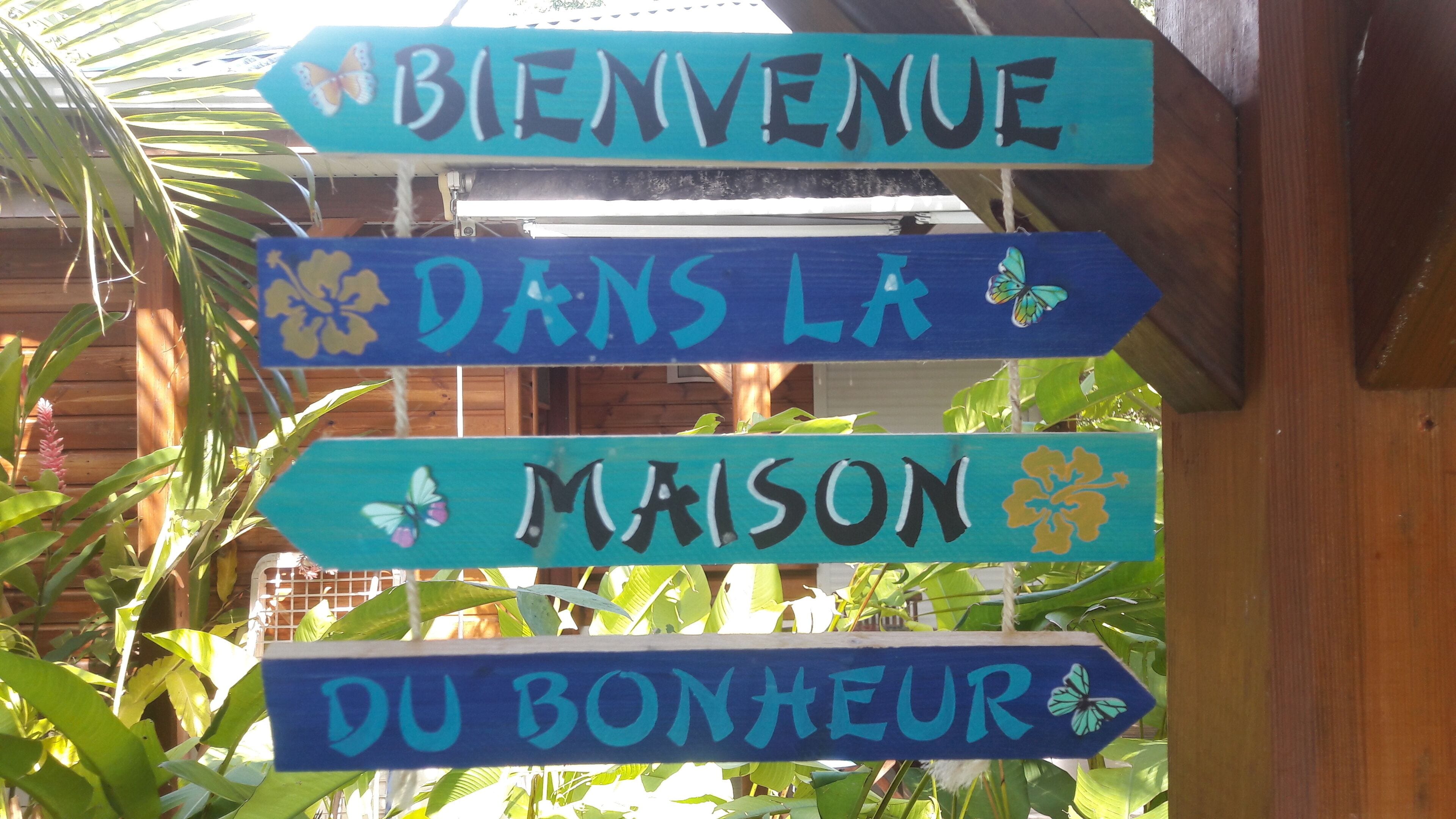 Un letrero de madera con texto en francés que muestra un mensaje de bienvenida.