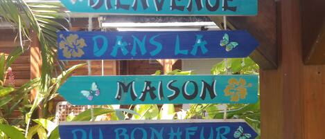 Un letrero de madera con texto en francés que muestra un mensaje de bienvenida.
