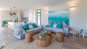 A modern living room with two sofas, a coffee table, and a kitchen in the background. - Kasalmar, Beach House 5StarsHome Mallorca, private swimming pool,air,wifi,beach. (Son Serra de Marina)