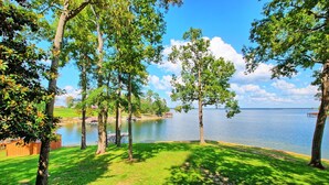 Une vue sur le lac, avec des arbres, une jetée et une zone herbeuse.