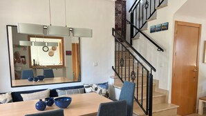 A modern living room with a dining area, a staircase, and a large mirror. - Stunning Villa with Private Heated Pool & Terrace JAC3 (Torre-Pacheco)