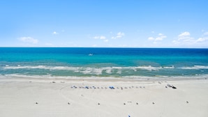 Una playa con cielo despejado y mar tranquilo.