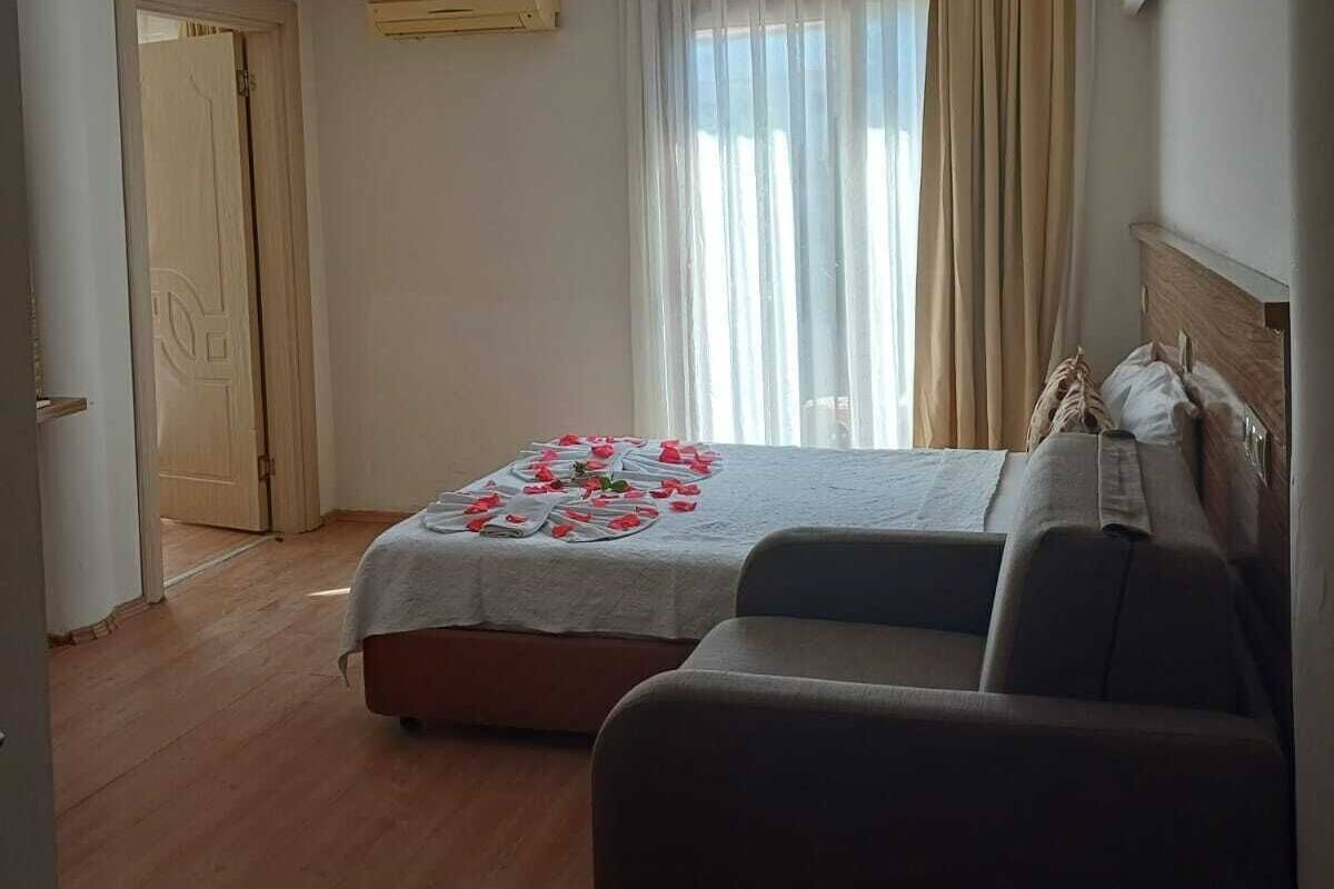 Una habitación de hotel con una cama, un sofá, una puerta y un equipo de aire acondicionado.
