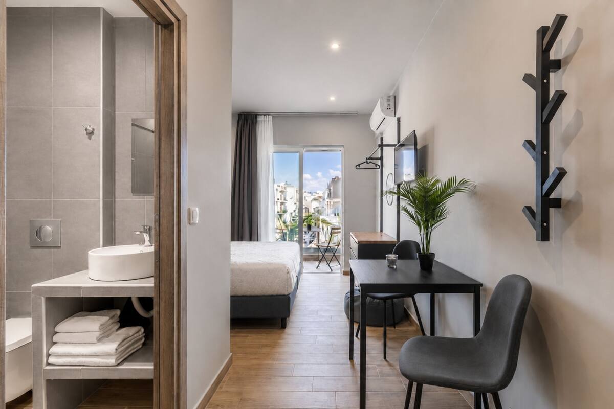 Une chambre d’hôtel moderne équipée d’une salle de bain, d’un lit, d’un bureau et d’une chaise.