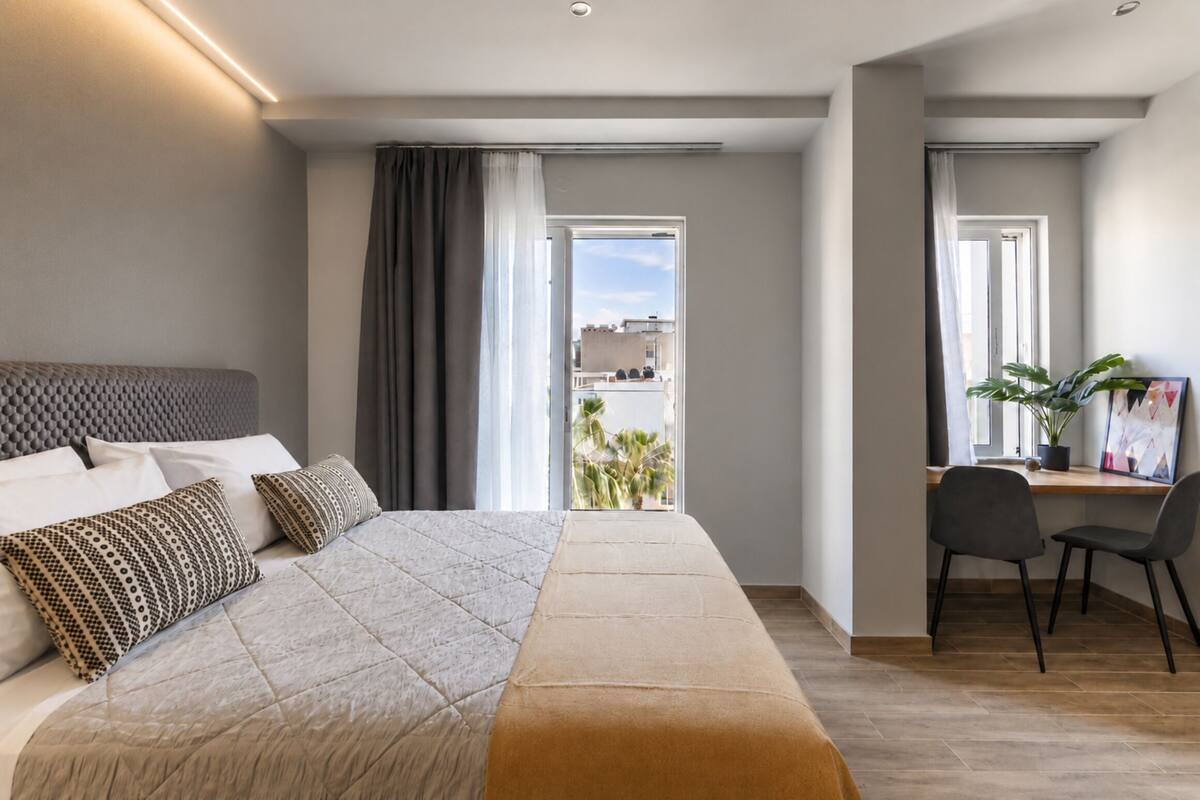 Une chambre d’hôtel moderne avec un grand lit, un bureau et une vue sur la ville.