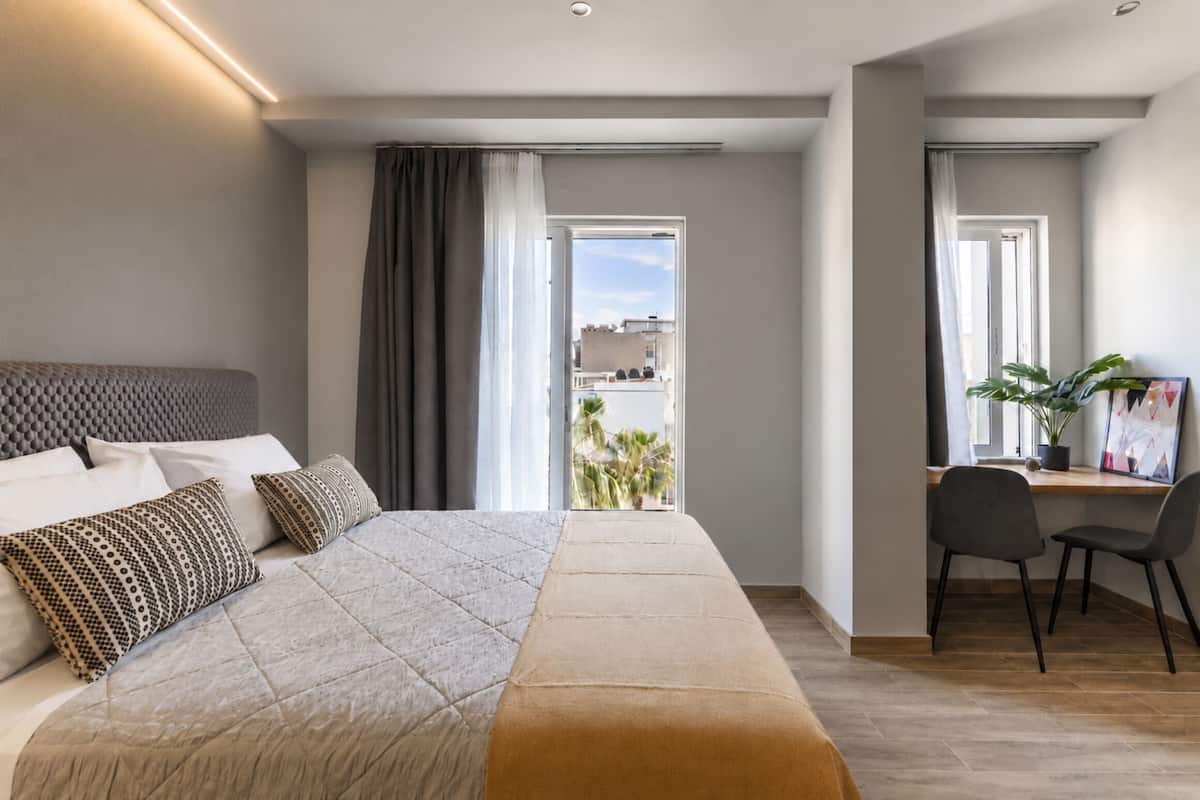 Ett modernt hotellrum med en stor sÀng, ett skrivbord och utsikt över staden.
