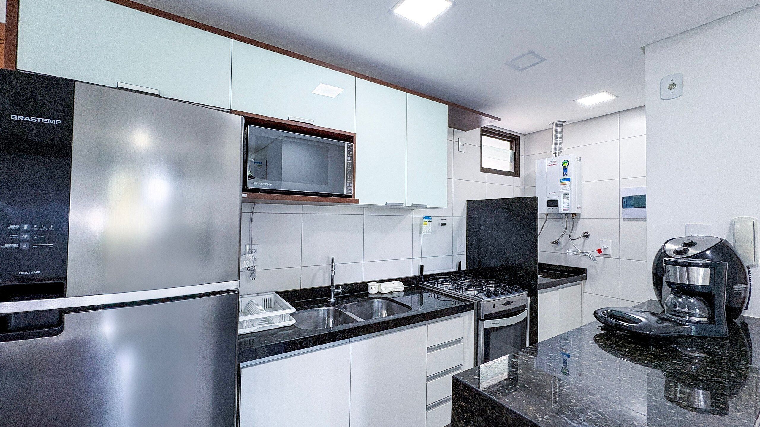 A modern kitchen with stainless steel appliances, a microwave, and a coffee maker.