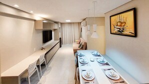 A modern kitchen with a dining area, a flat-screen TV, and a painting on the wall. - Beach Class Residence Eco Life (Ipojuca)