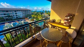 A balcony with wicker furniture, a small table, and potted plants. - Beach Class Residence Eco Life (Ipojuca)