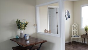 A dining area with a wooden table and benches, a vase with flowers, and a window with a view. - Minutes to DE TURF FIELDS.  Quiet beach community.   (Frederica)