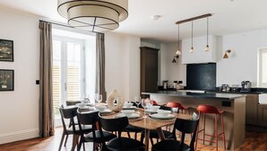 Een moderne keuken met een eethoek, houten vloeren en een groot raam.