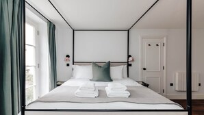 Een moderne hotelkamer met een groot bed, een uitzicht door het raam en een deur.