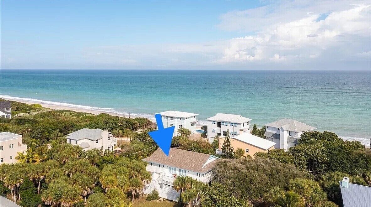 Une propriété située sur la côte, comprenant plusieurs bâtiments, un accès à la plage et une végétation luxuriante.