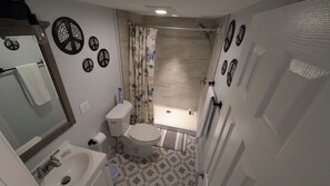 Tina con regadera, bidet, toallas, papel de baño 