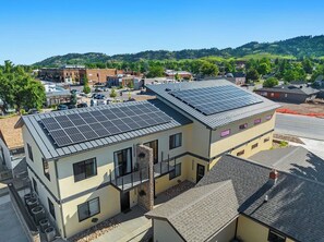 Un bâtiment moderne doté d’un toit plat, d’un balcon et d’une installation de panneaux solaires.