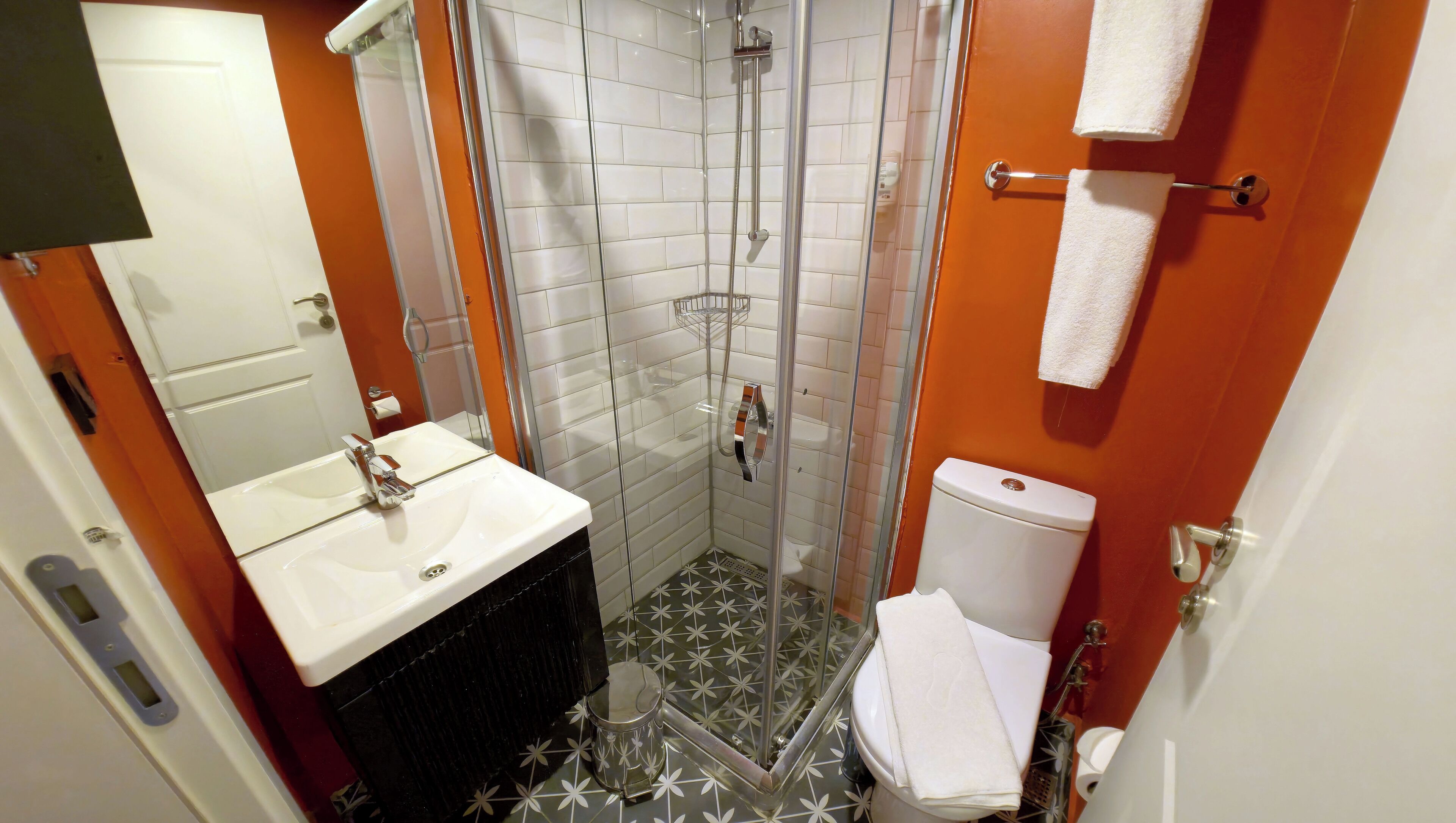 Un bagno con doccia, WC, lavandino e specchio.