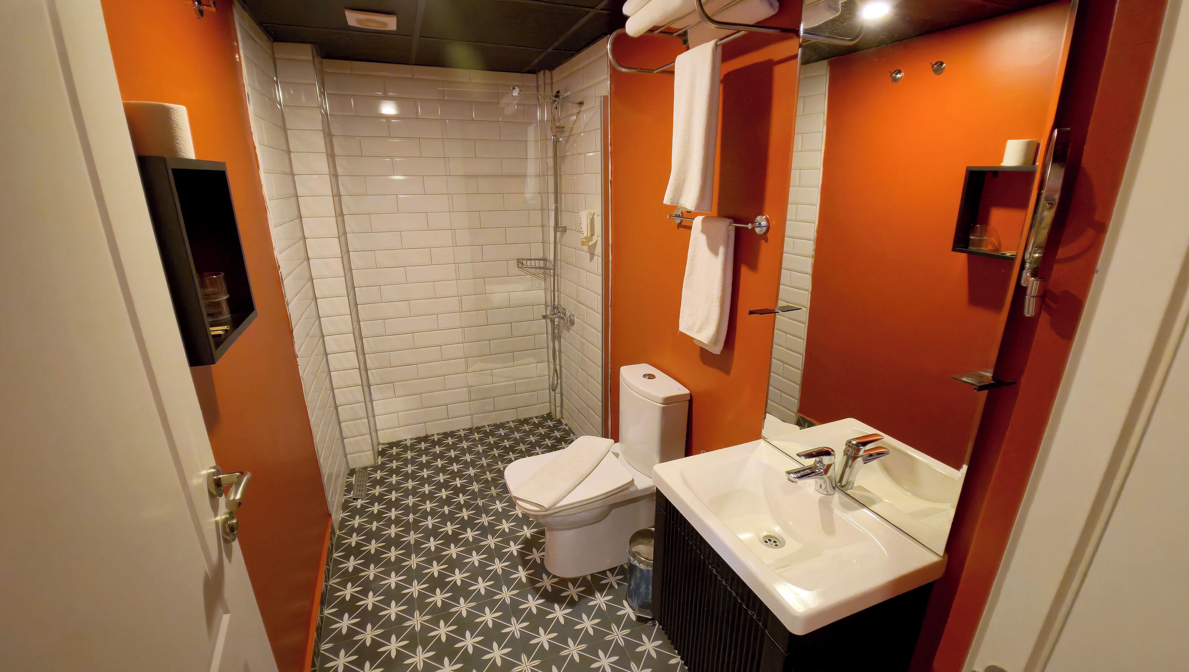 A bathroom with a shower, toilet, and sink.