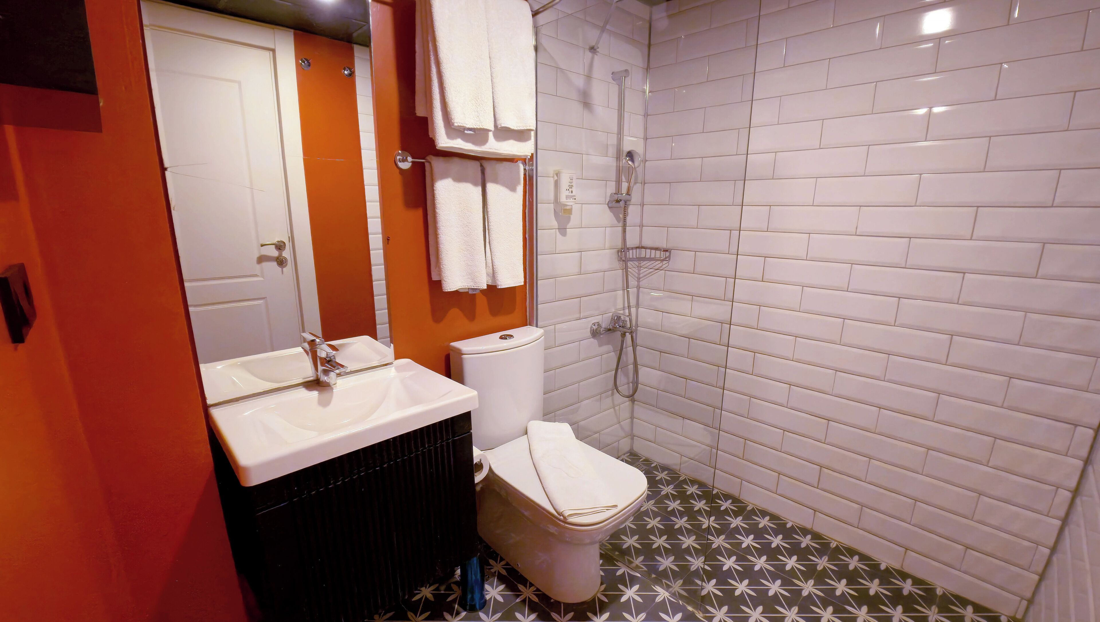 A bathroom with a white sink, a toilet, and a shower.