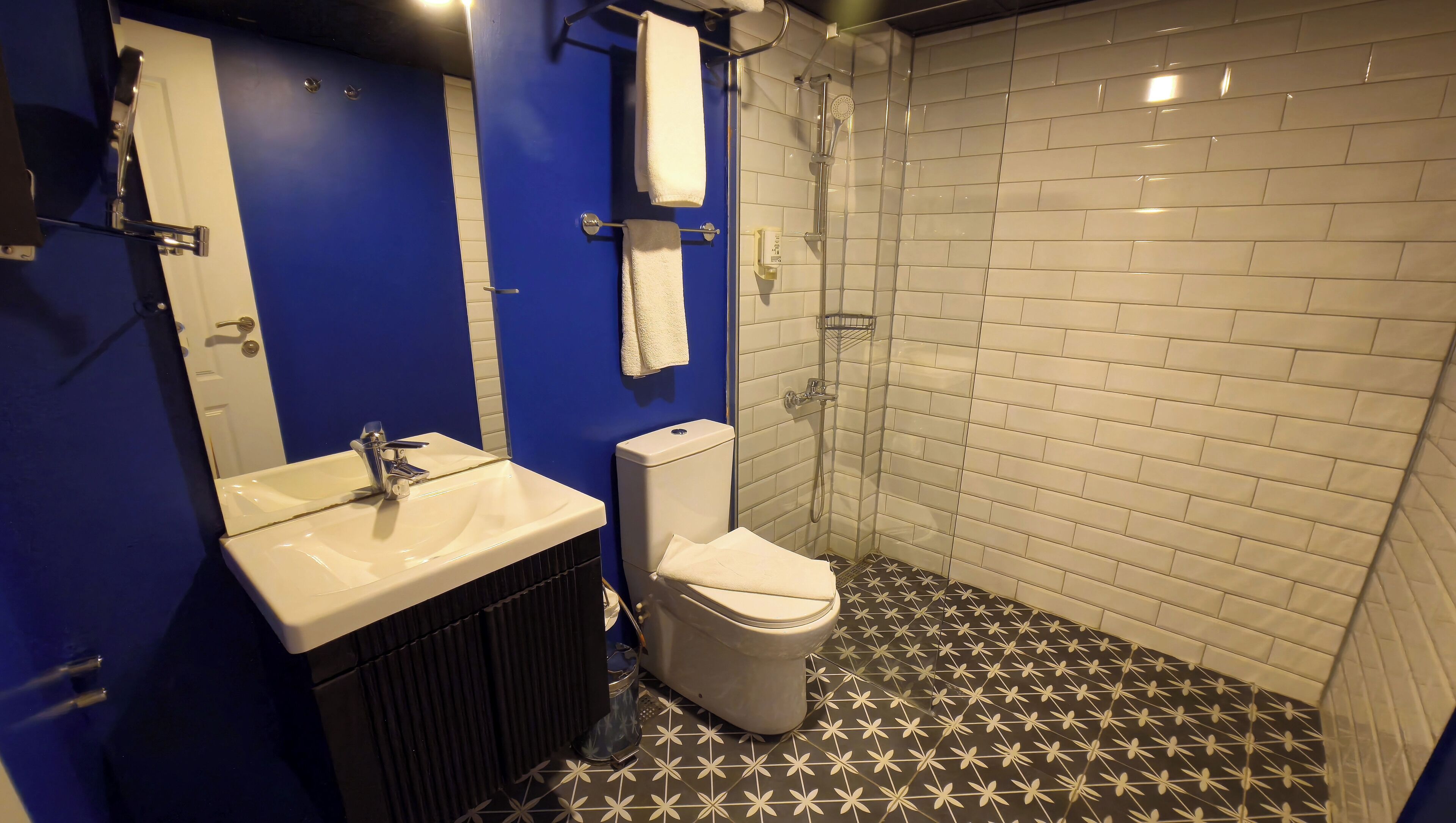 A bathroom with a white sink, a toilet, and a shower area.
