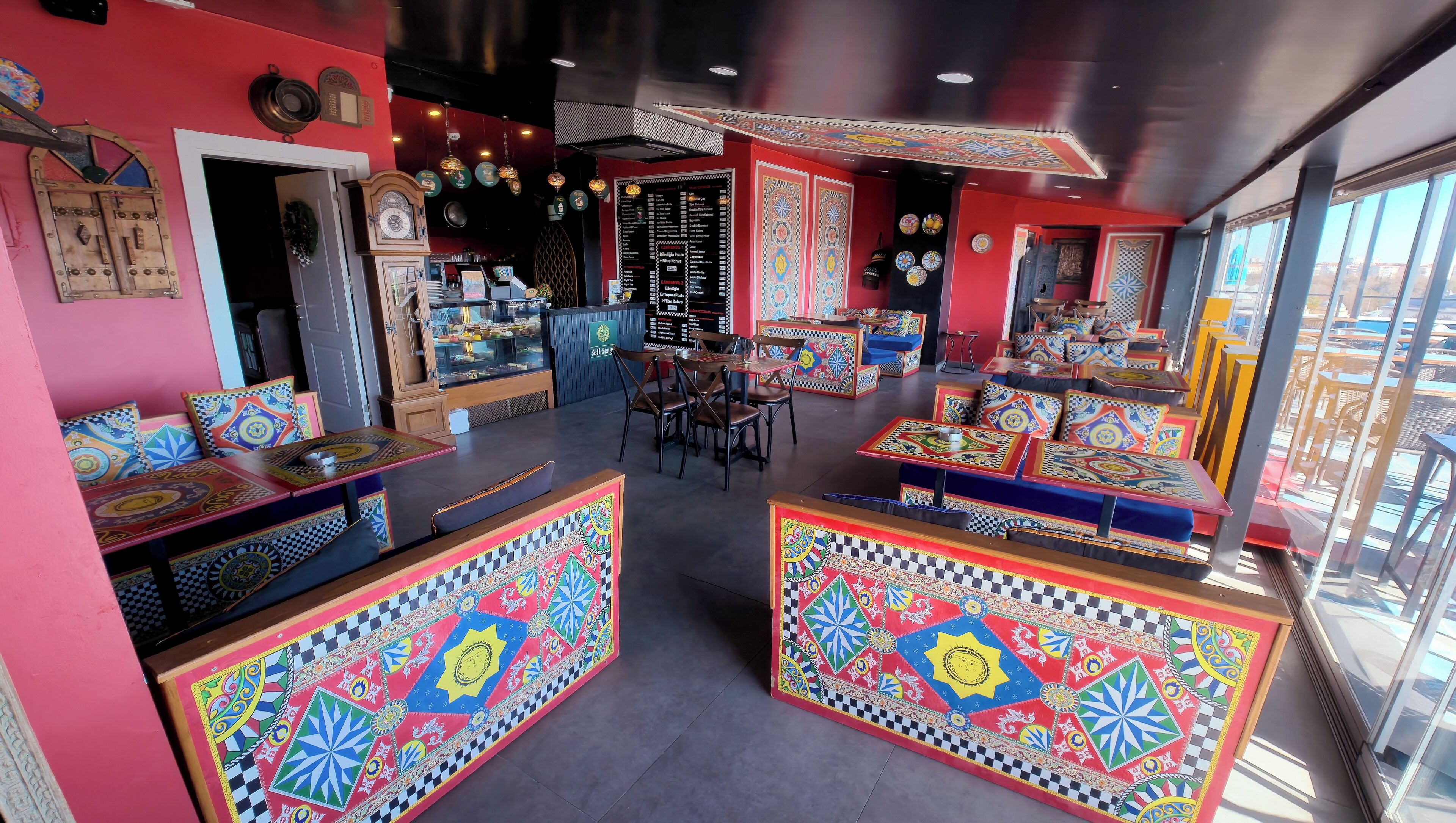 A vibrant interior with colorful seating arrangements, a central dining area, and a menu board.