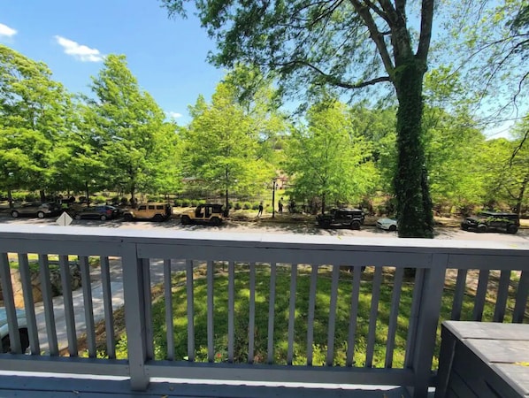 Relax on the outdoor deck with a serene view of the surrounding trees.