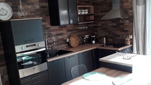 Een praktische keuken met een inbouwoven, een koffiezetapparaat en een spoelbak.