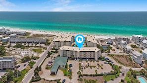 A resort with multiple buildings, a parking lot, and a beach. - Stunning Condo on The Beach - (Santa Rosa Beach)