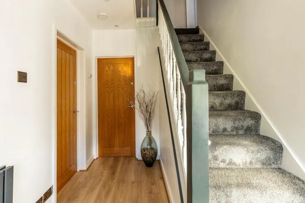 A staircase with a handrail and carpeted steps leading to an upper floor.