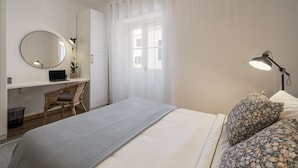 A bedroom with a bed, a desk with a laptop, a chair, a round mirror, and a lamp. - In the Funchal Old Town, near beach - Casa Caetano (Funchal)