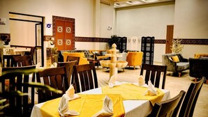 A dining area with tables set for two, featuring yellow tablecloths and white napkins. - EL MOUSSAFIR HOTEL (Marrakech)
