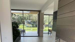 Um interior moderno com uma grande porta de vidro deslizante que dá para um espaço de pátio.