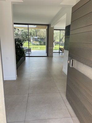 Un intérieur moderne avec une grande porte-fenêtre coulissante donnant sur un patio.