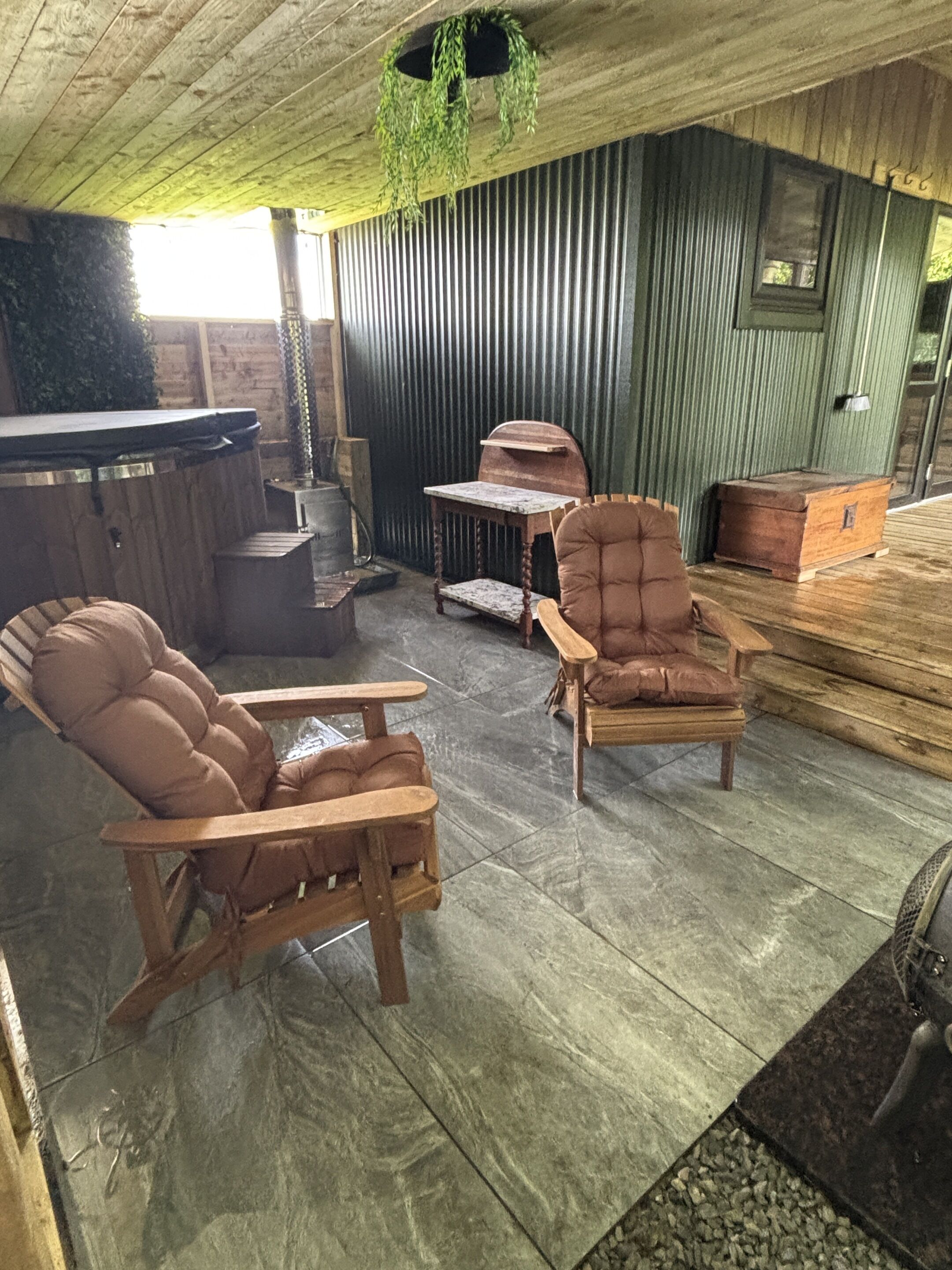 A rustic interior with wooden furniture, a bar, and a green hanging plant.
