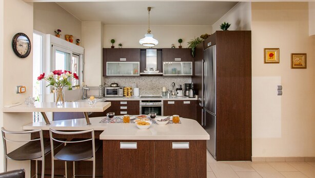 Una cocina moderna con una isla central, electrodomésticos de acero inoxidable y armarios de madera.
