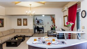 Una sala de estar moderna con un sofá, una mesa de centro y un comedor con una mesa dispuesta para el desayuno.