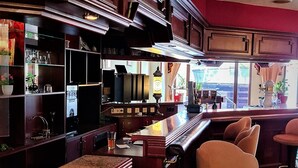 Eine Bar mit hölzernen Barhocker und einer Theke.