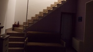 A staircase leading to a landing with a chair and a radiator on the landing. - Malu's House (Castelluccio Superiore)